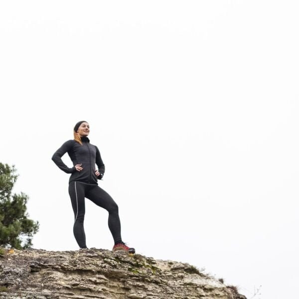 ### **Texto Alternativo (Alt Text) para la Imagen:** Agencia SEO Guatemala - Mujer en ropa deportiva escalando una roca, simbolizando esfuerzo y perseverancia.